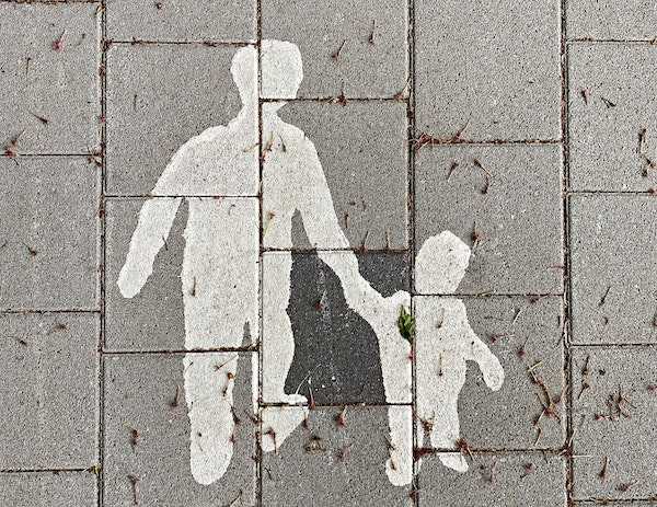 A sidewalk painting of a parent and child holding hands.