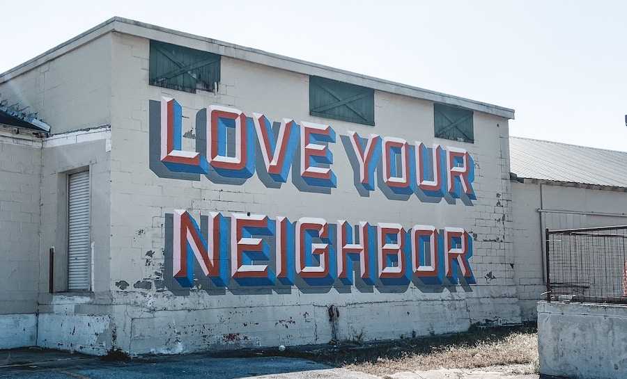 A building with graffiti that says, "love your neighbor".